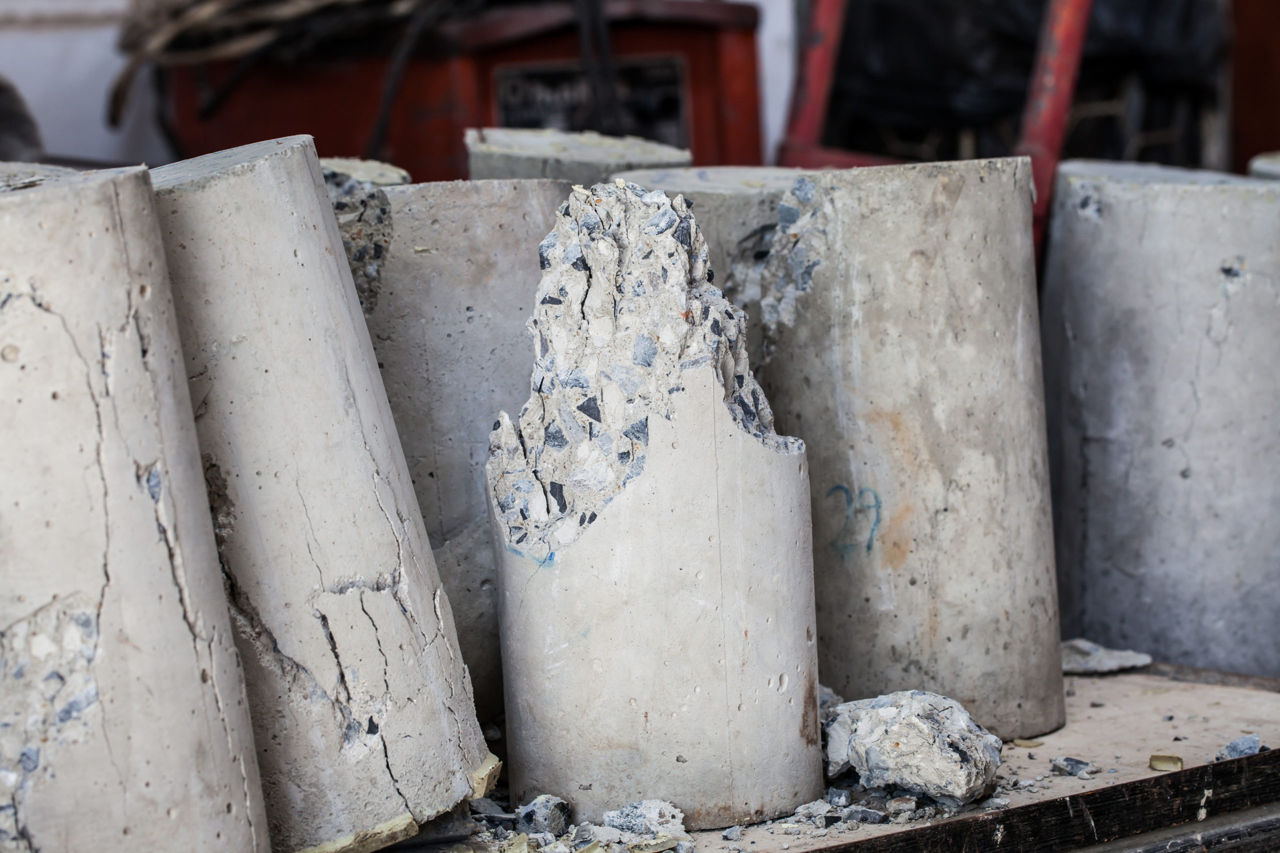 A cluster of concrete cylinder samples rest together after being cracked from compression testing.